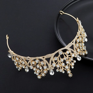 Close-up of golden crown with teardrop rhinestones on black background display