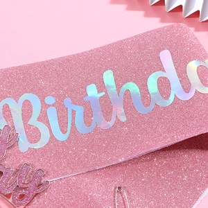 Detail of pink sequin birthday sash with holographic silver text and matching cake topper