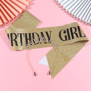 Detail of glitter birthday girl sash and rhinestone tiara set on pink party background
