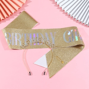 Birthday Girl set with gold glitter sash, rhinestone headband, and safety pin on pink decor