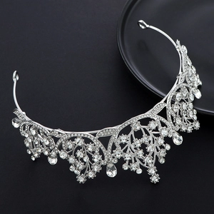 Detail of silver bridal crown with intricate hollow patterns and crystal teardrop pendants