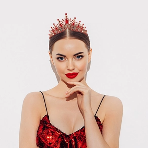 Détail d'une couronne dorée avec cristaux rouges et rubis portée par un modèle