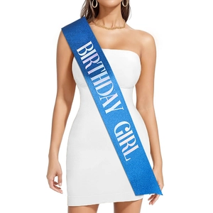 Gros plan sur l'écharpe Birthday Girl à paillettes bleues sur une robe blanche de fête
