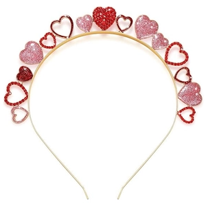 Dettaglio di un cerchietto dorato con strass rossi scintillanti e cuori rosa glitter