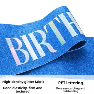 Détail de l'écharpe d'anniversaire bleue pailletée avec lettrage BIRTH holographique