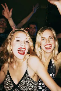 Donne che indossano cerchietti XOXO di paillettes rosse a una festa di San Valentino
