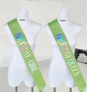 Détail des écharpes à paillettes vertes avec texte holographique Birthday Girl et Queen