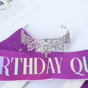 Close-up of a silver crystal crown and purple glitter sash with Birthday Queen lettering