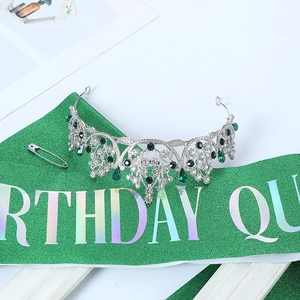 Detailed shot of silver crown with green teardrop gems and matching birthday queen sash