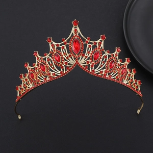Gros plan d'une couronne baroque dorée avec cristaux rouges et pierres marquises