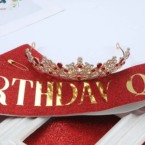 Close-up of birthday queen sash and glittering rose gold crown party accessory set