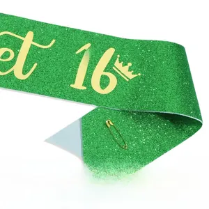 Détail de l'écharpe verte scintillante Sweet 16 avec couronne dorée et épingle