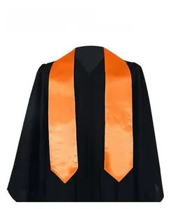 Detailed view of orange satin graduation stole draped over a black academic robe