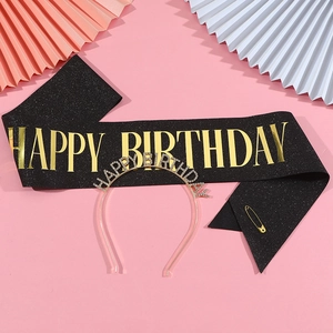 Flat lay of Happy Birthday black glitter sash and gold rhinestone headband set