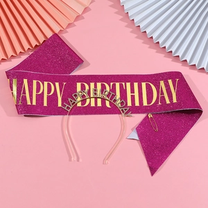Close-up of pink glitter sash with gold Happy Birthday text and rhinestone metal headband