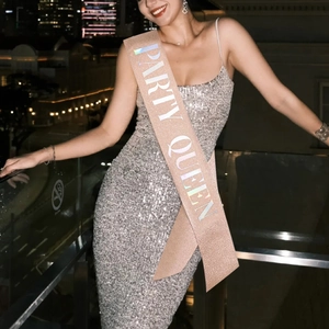 Close-up of rose gold glitter Party Queen sash with holographic laser lettering on a model