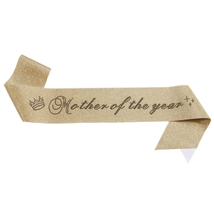Macro detail of Mother of the Year sash with gold glitter fabric and black rhinestone text