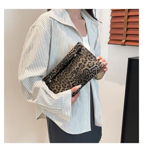 Detail of leopard print clutch bag showing soft texture and elegant metal clasp
