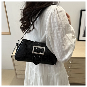 Detail of black crocodile texture shoulder bag featuring silver metal buckle and strap