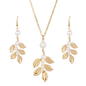 Vue détaillée de l'ensemble collier feuille dorée et boucles d'oreilles perles élégantes