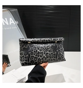 Detail of leopard print clutch with smooth faux leather texture and gold buckle hardware