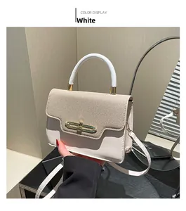 Detail of contrast color crossbody bag with white leather handle and gold hardware buckle