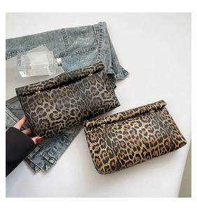 Detailed top view of leopard print clutch bags with zipper on denim background