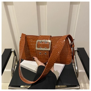 Detail of caramel brown croc-embossed shoulder bag with a large silver square buckle