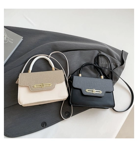 Detail of elegant two-tone crossbody bags with gold hardware and contrast textures
