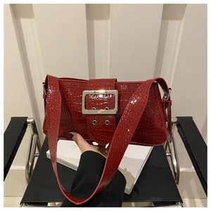 Detail of dark red crocodile embossed patent leather with silver square buckle