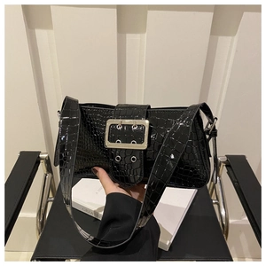 Close-up of black crocodile embossed patent leather bag with a large silver metal buckle