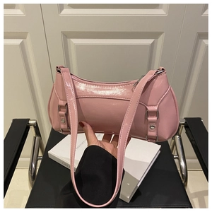 Detail of pink patent leather baguette bag with dual straps and glossy finish