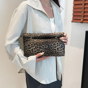 Classic leopard print envelope clutch bag with metal snaps held by a stylish model