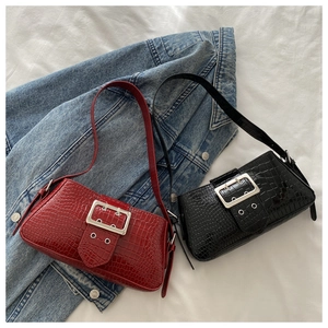 Detail of red and black faux crocodile leather shoulder bags with metal buckle