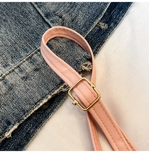Detail of pink faux leather bag strap with golden square buckle and fine stitching