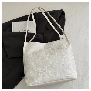 Gros plan détaillé de la texture en dentelle blanche sur un sac fourre-tout minimaliste