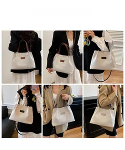 Model display of large canvas tote bag showing shoulder strap and crossbody options