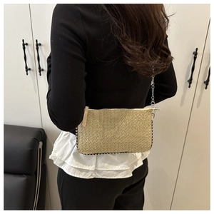 Detail of raffia woven crossbody bag with silver beaded chain fringe and shoulder strap