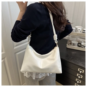 Détail du sac hobo blanc montrant la bandoulière nouée et la texture du similicuir brillant