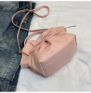 Detailed close-up of pink ruched cloud bag with elegant bow drawstring and PU leather strap