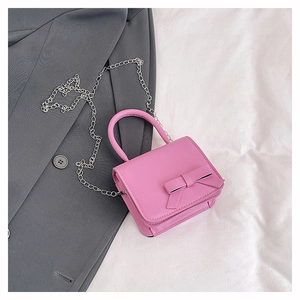Detailed close-up of pink mini crossbody bag with a decorative bow on the front flap