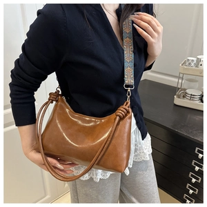 Détail du sac cabas marron avec poignée nouée et bandoulière tissée ethnique au style rétro