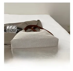 Close-up of the durable rectangular canvas base with brown leather accents and stitching