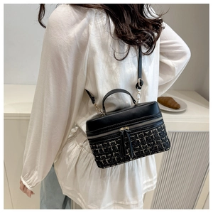 Détail du sac à main en tweed et cuir avec fermetures éclair dorées et poignée supérieure