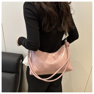 Détail d'un sac cabas rose nacré avec nœuds porté par un mannequin de dos