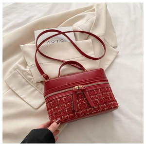 Détail du sac à bandoulière en tweed rouge et cuir avec fermetures éclair dorées