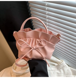 Détail du sac à main rose avec bords à volants, nœud élégant et texture mate douce