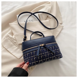 Détail du sac à main en tweed bleu marine et cuir avec tissage métallique doré