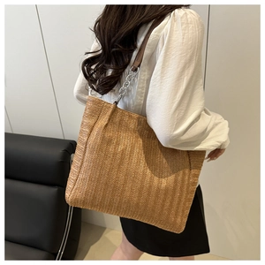 Large capacity straw woven tote bag with leather chain strap shown on a model