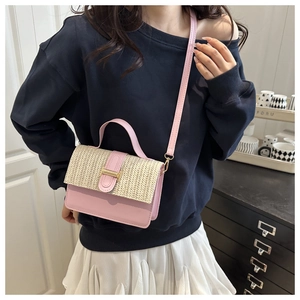 Pink woven patchwork crossbody bag on model with blue sweatshirt and white pleated skirt